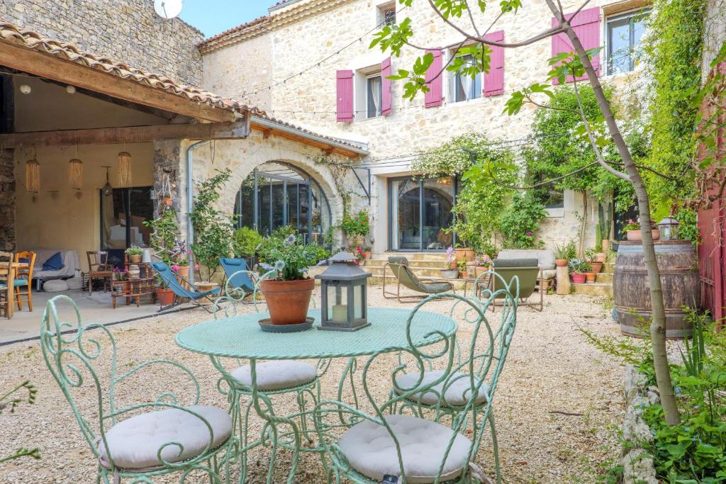 an outdoor patio with a table and chairs at Chambres D’hôtes - Les Agrions in Saint-Remèze