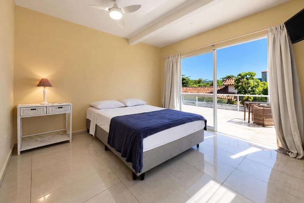 a bedroom with a bed and a large window at Pousada in Guarujá