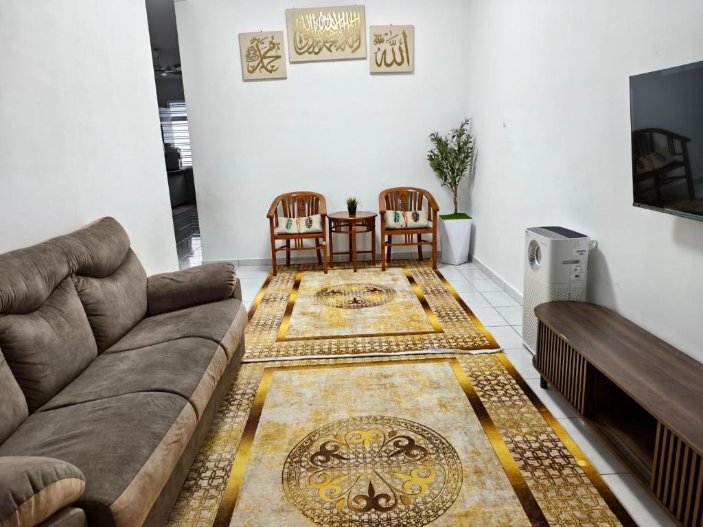a living room with a couch and a table and chairs at TheRapy House in Malacca