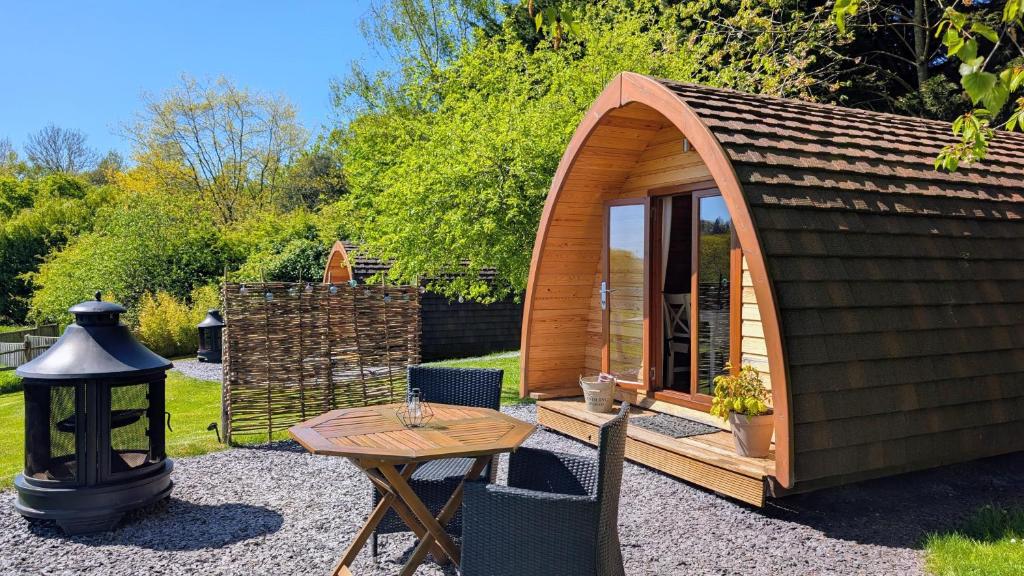 a small wooden cabin with a table and a table at Glamping at Honnington Farm in Royal Tunbridge Wells