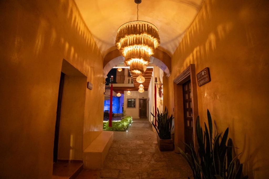 a hallway with a large chandelier in a building at Hotel Bitos Boutique in San Miguel de Allende