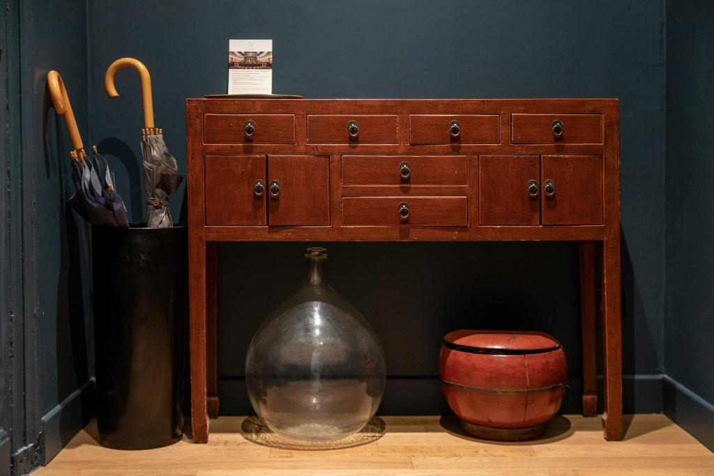 a wooden dresser with a vase sitting underneath it at Chambre De Charme Aux Chartrons in Bordeaux
