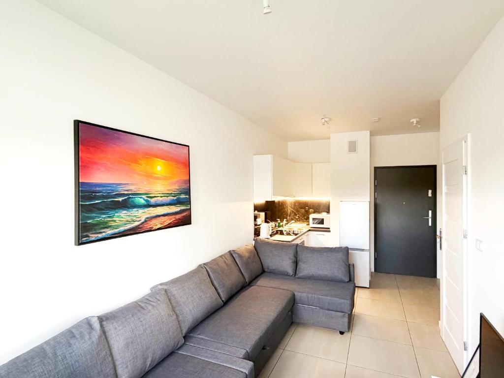 a living room with a couch and a painting on the wall at Apartament Gozo in Łódź