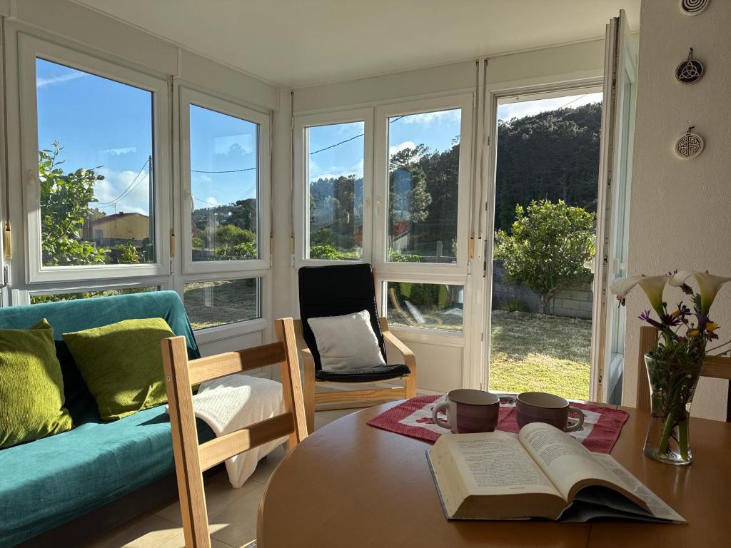 a living room with a table with books on it at Casa Frutales - Landhaus mit Garten nahe Strand und Finisterre in Fisterra