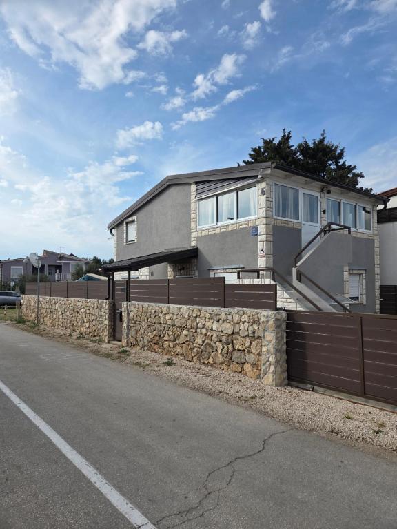 a house on the side of a road with a fence at Apartment Vi & La ELECTRIC SCOOTERS included in Vir