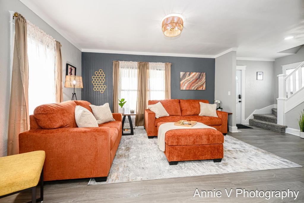 a living room with two orange chairs and a couch at Hannahs Haven in Lima