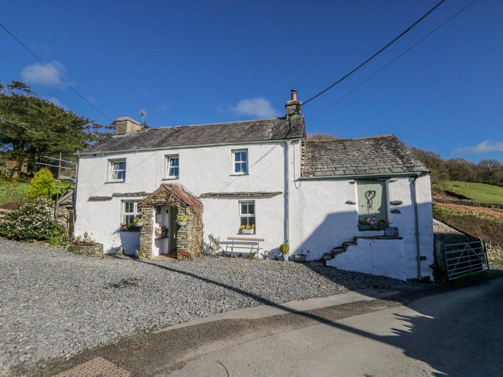 a white house on the side of a road at High Ickenthwaite Farmhouse in Ulverston