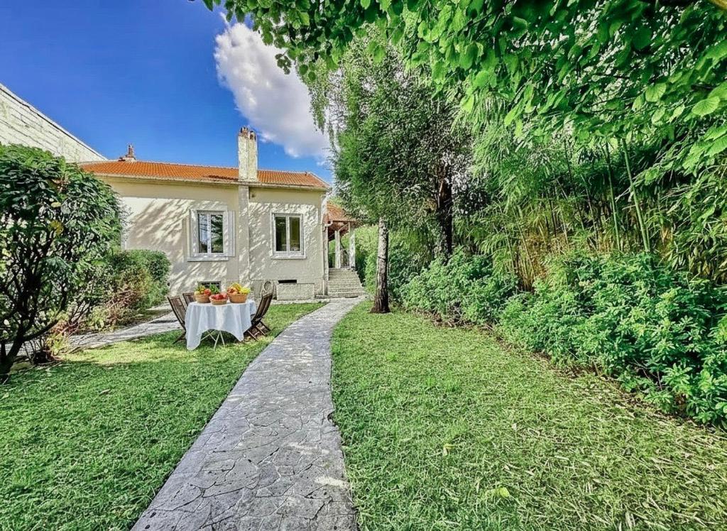 a stone path leading to a white house at Villa arborée aux Portes de Paris proche Stade de France, Zenith, Le Bourget, CDG, Parc Asterix in Bobigny