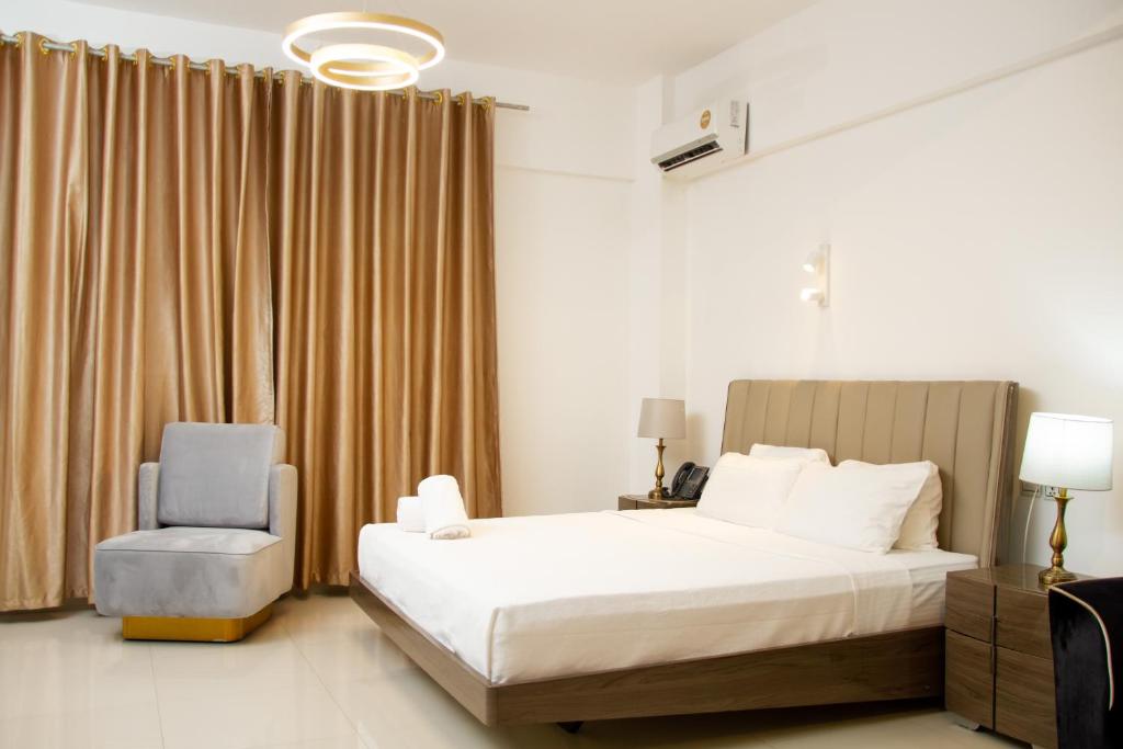a bedroom with a bed and a chair at Hotel Kilimanjaro in Luanda