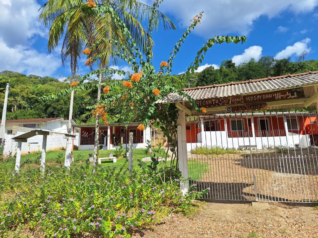 a building with an orange tree in front of it at Hospedagem Horizonte Azul- Recanto São Thomé in Eldorado