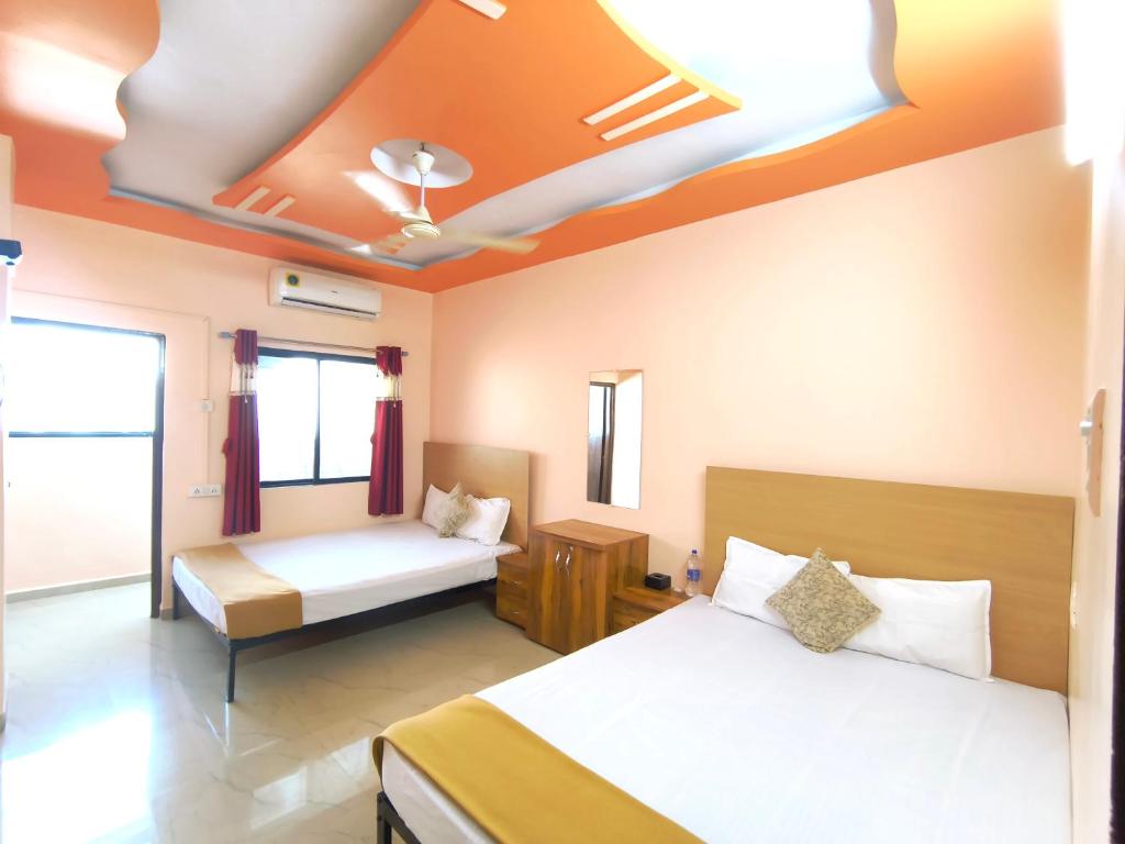 a bedroom with two beds and a ceiling at Ambient Homestay NESTEASY in Nashik