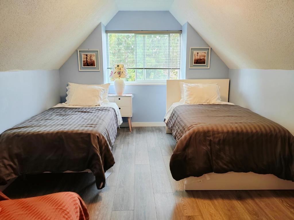 a attic bedroom with two beds and a window at Bed Plus One in House in Richmond