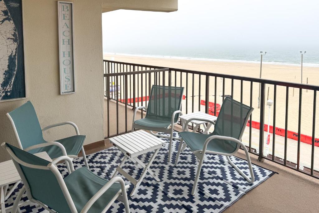 a balcony with four chairs and a beach at Walk to Boardwalk! Waterfront Ocean City Condo in Ocean City