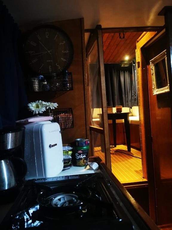 a kitchen with a clock on the wall and a refrigerator at Eco Yacht Charters in Almere