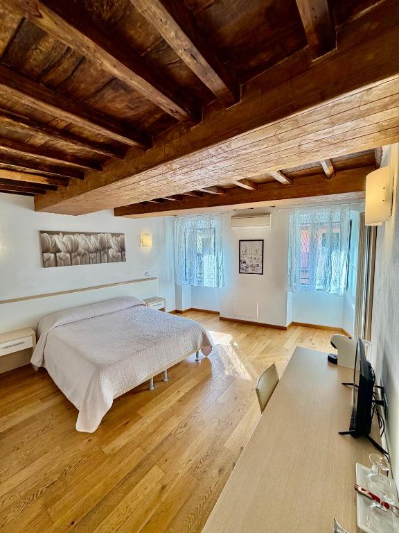 a bedroom with a large bed and wooden floors at La Dolce Vita in Riomaggiore