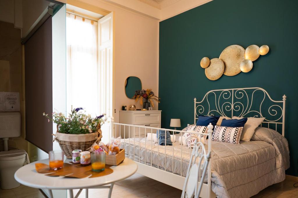 a small room with a bed and a table with a table at B&B ELEGANT LENA in Salerno