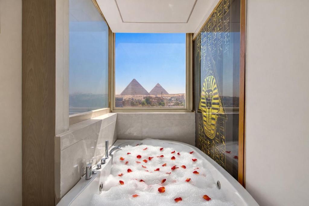 a bathroom with a bath tub with roses in a window at Superior Pyramids View in Cairo