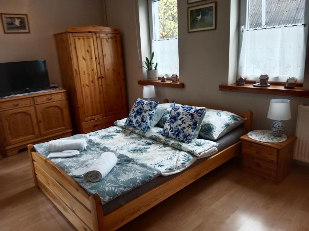 a bedroom with a bed with pillows and a tv at ZŁOTY BUK in Jagniątków