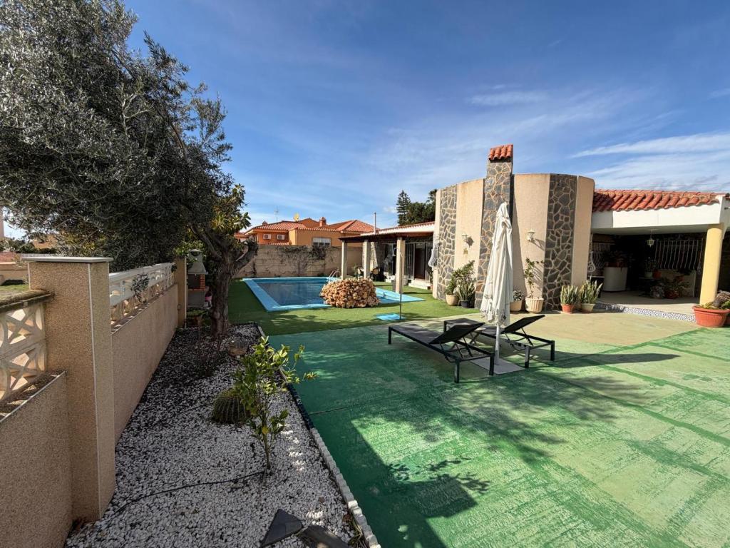a house with a green yard with a swimming pool at Chalet con Piscina Aguadulce in Aguadulce