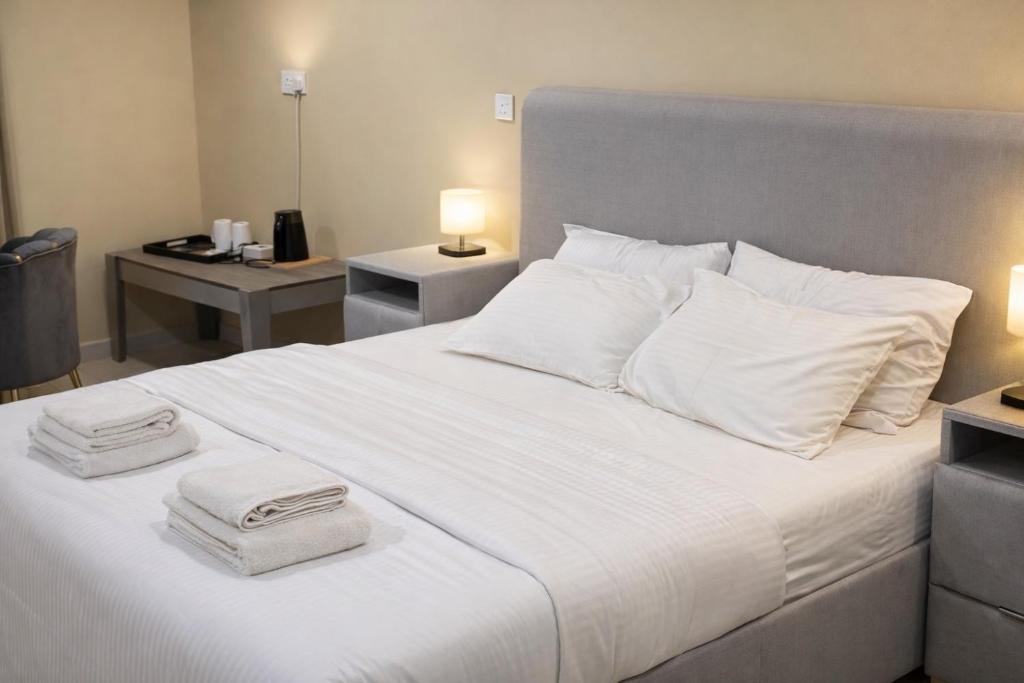 a bedroom with a white bed with two towels on it at Alsharafh room 2 in Al ‘Aqar