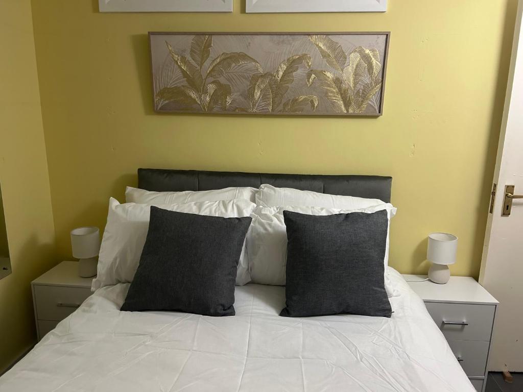 a bedroom with a white bed with two pillows at 7 The Diamond in Ballycastle