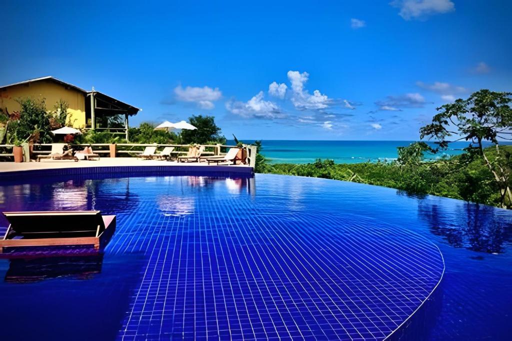a swimming pool with blue tiles on the water at Villas do Pratagy VIP in Maceió