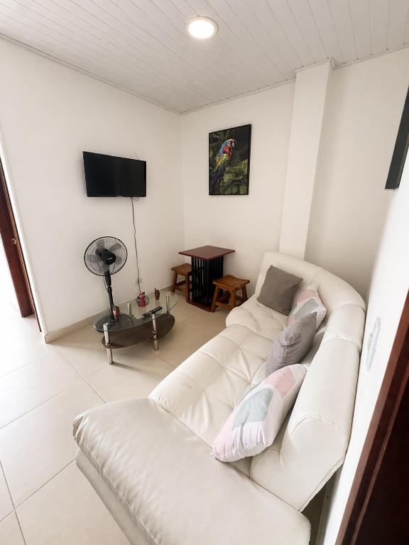 a living room with two white couches and a television at Acogedor apartamento in Leticia