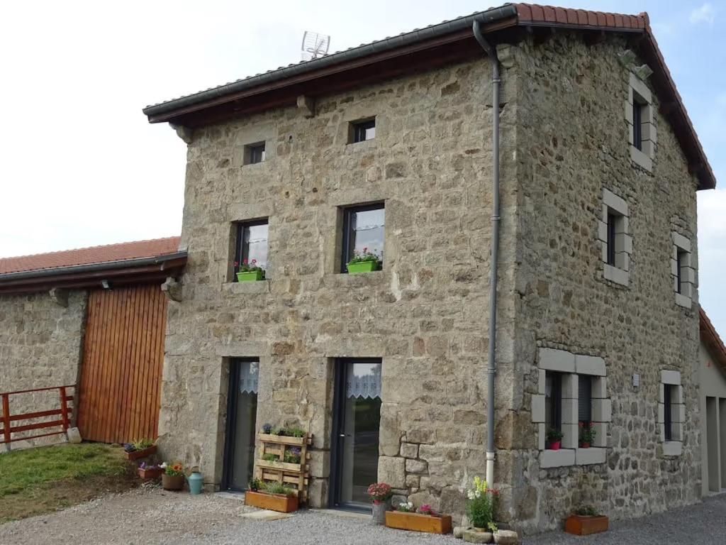 a large stone building with windows and plants at Airellier du Pilat in Marlhes