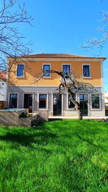 a large house with a green lawn in front of it at Casa de St António in Murtosa