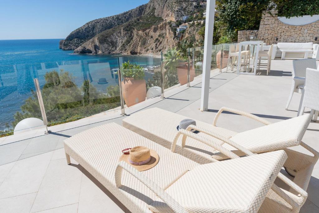 a patio with a table and chairs and the ocean at Maryvilla Inspiración y Vacaciones - Villa Mascarat in Calpe