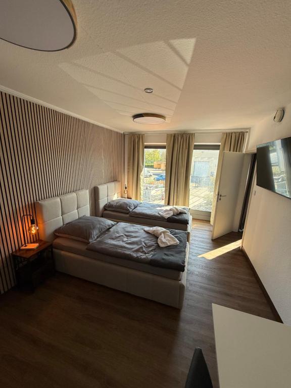 a bedroom with two beds and a large window at GARLAND Rooms in Bremen