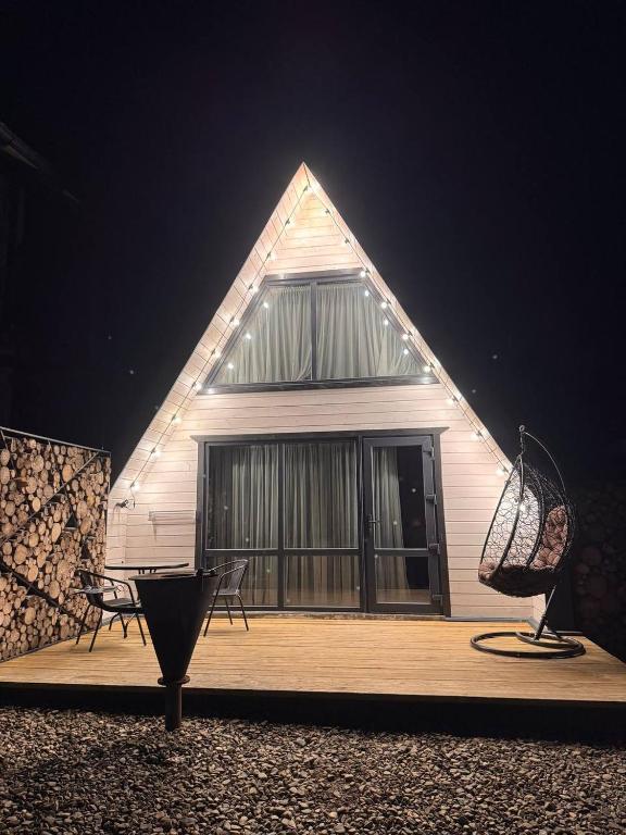 a building with a pointed roof with two chairs on a deck at A-frame У Евелінки in Vorokhta