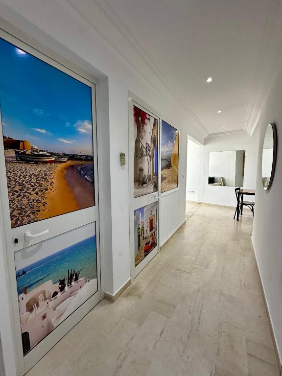 a hallway with three large pictures on the walls at Appartement Laetitia, hyper centre hammamet in Hammamet