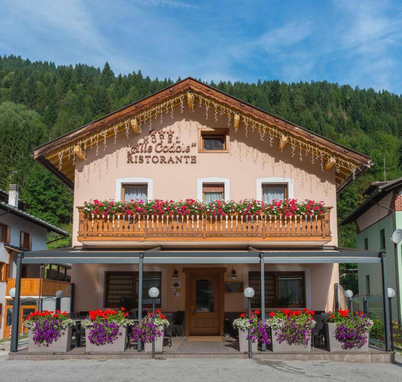 a building with a balcony with flowers on it at Albergo Ristorante Alle Codole in Canale dʼAgordo