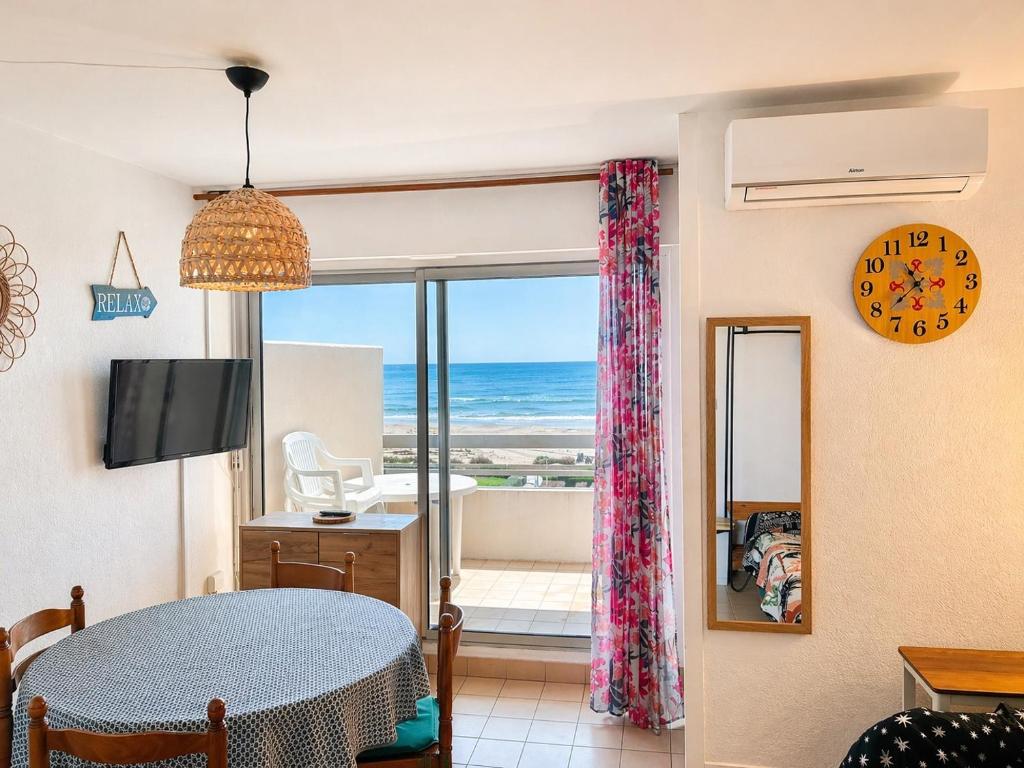 a living room with a view of the ocean at Studio cabine pied dans l eau climatisé, parking et wifi haut débit in Canet-en-Roussillon
