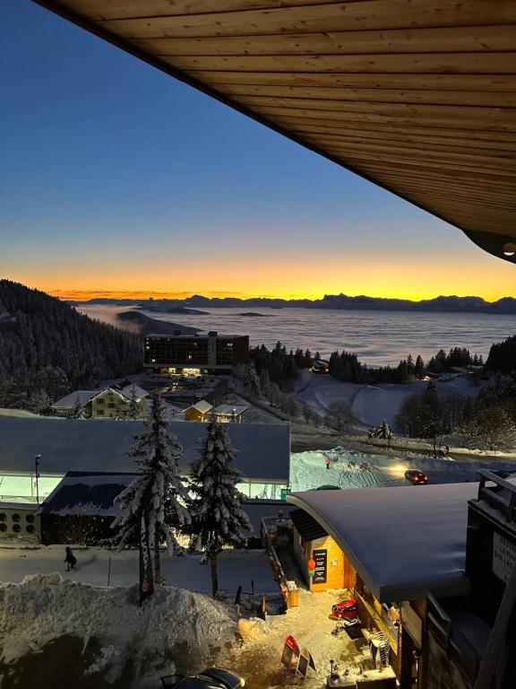 a view of a town in the snow at sunset at Duplex « les 7 Marmottes », 306 in Chamrousse