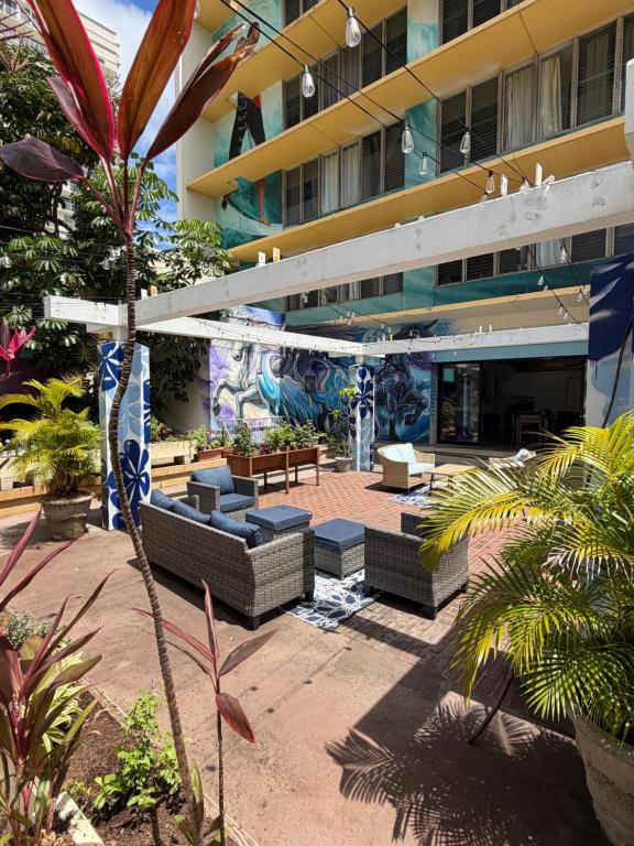 a hotel with a patio with couches and a building at Central YMCA Residences in Honolulu