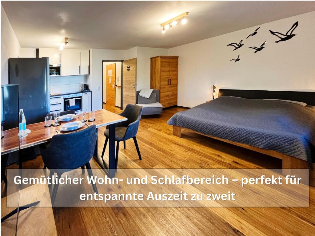 a bedroom with a bed and a table with chairs at Ruhige Ferienwohnung Seemöwe mit Balkon - ideal für Paare & Radurlauber in Radolfzell am Bodensee