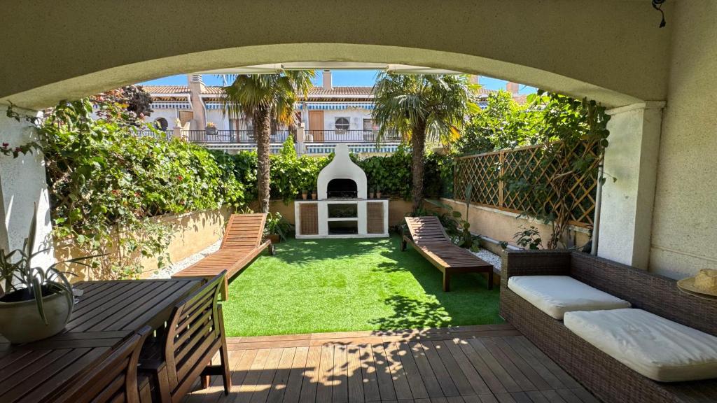 an outdoor patio with benches and a yard with grass at Casa de playa in Roda de Bará