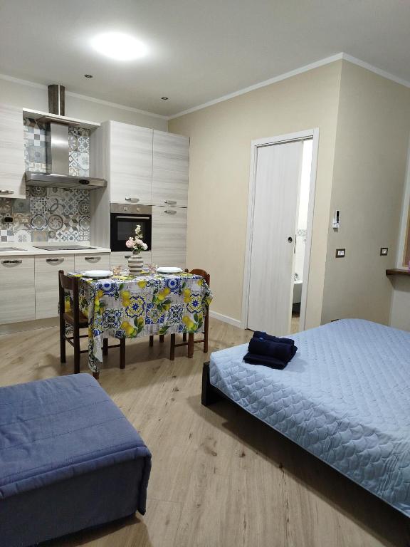 a bedroom with a bed and a table and a kitchen at Mono perfetto per Ospedale e Treni Check-in rapido in Livorno