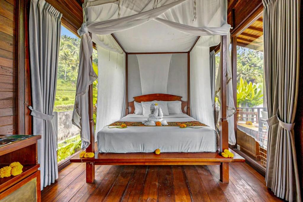 a bedroom with a canopy bed with a window at Escape To Paradise With Private Pool in Silebeng