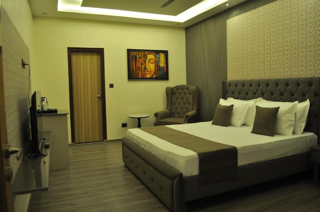 a hotel room with a bed and a chair at The Royal Palace Inn in Almora