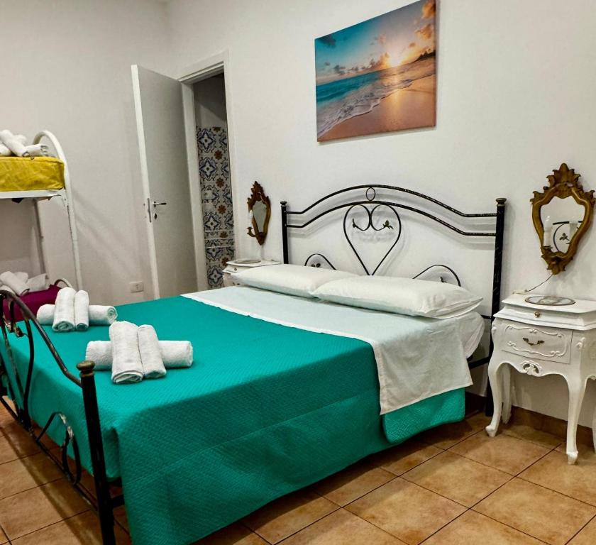 a bedroom with a bed with a green and white blanket at DomusVenere in Santa Croce Camerina