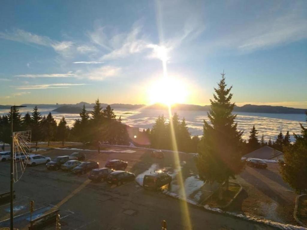 a view of a parking lot with the sun setting at « Le doux Chalet » Roche Béranger in Chamrousse