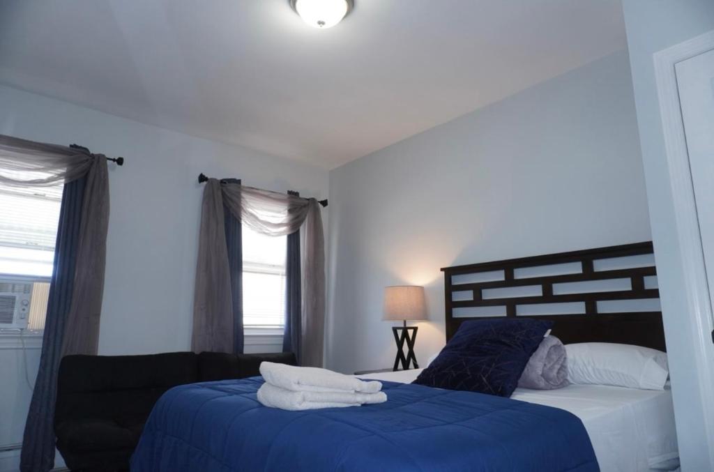 a bedroom with two beds with blue and white sheets at West New York room 14 in West New York