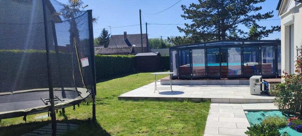 a glass house with a table in a yard at Les étoiles de la Baie in Lanchères