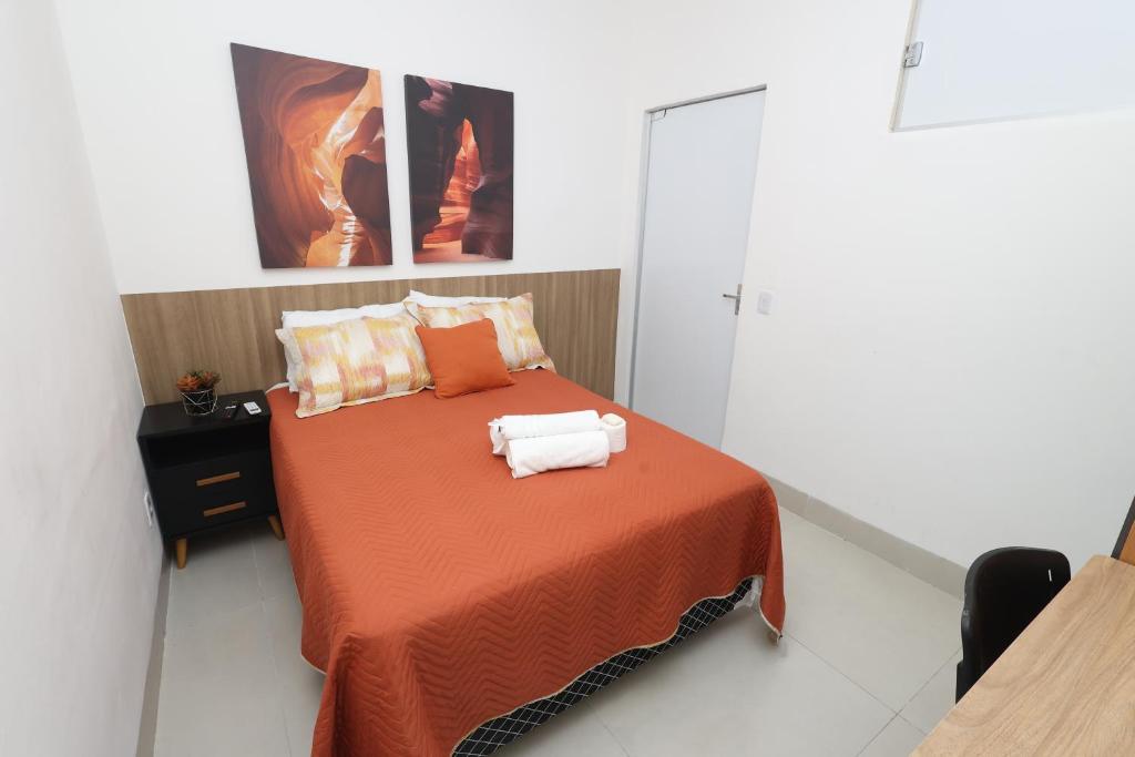 a bedroom with a bed with two towels on it at Pousada House Garden in Goiânia