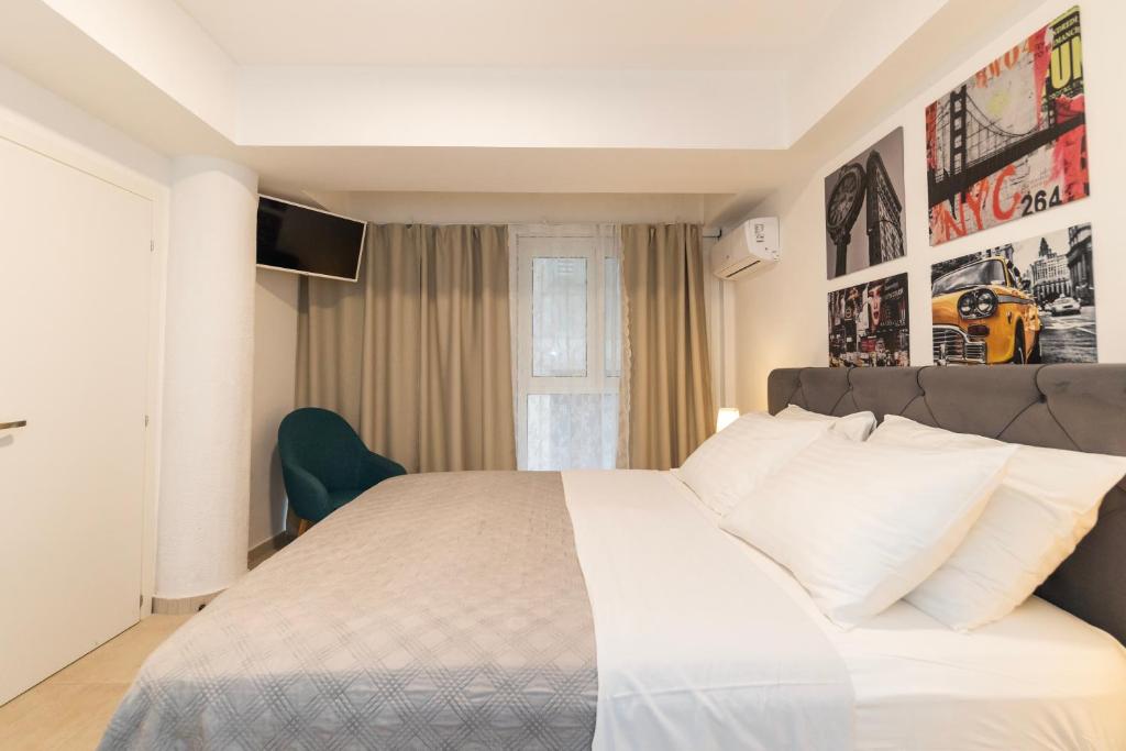 a bedroom with a large white bed and a window at CentRooms Kovac in Zadar