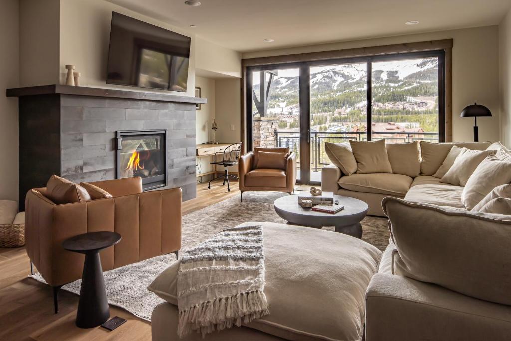 a living room with a couch and a fireplace at Mountain Lake Condo Unit 402D in Big Sky