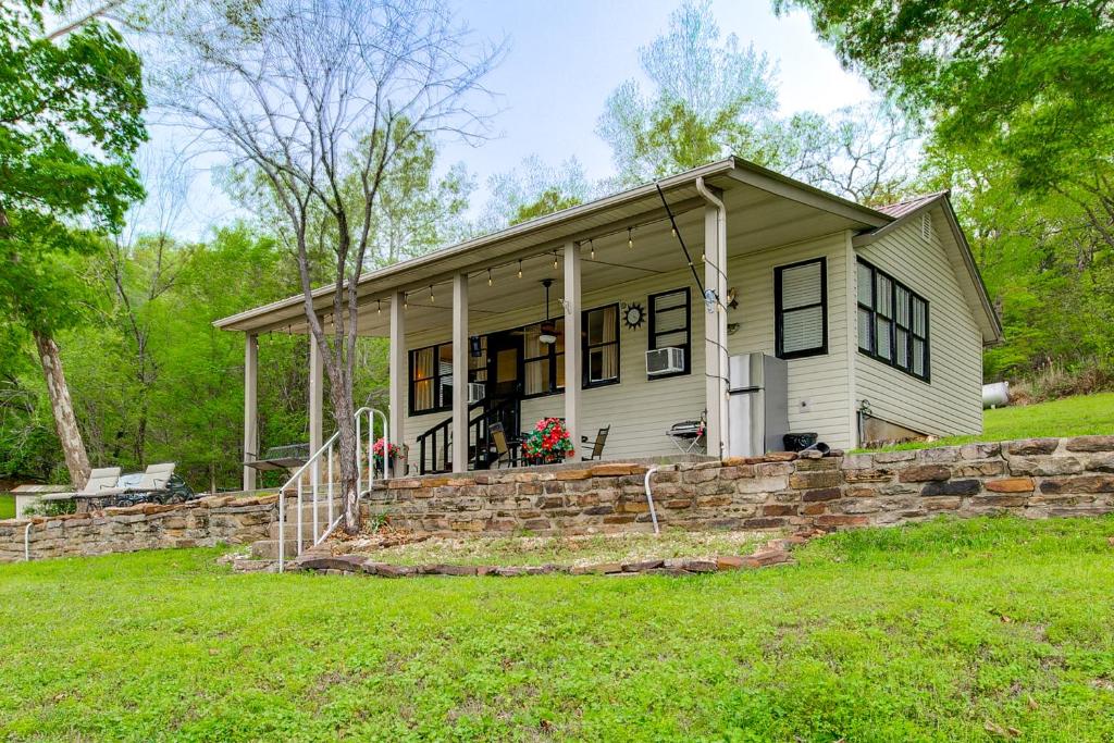 a small house with a stone wall at Lakefront Ozarks Home w/ Private Dock & Patio! in Roach